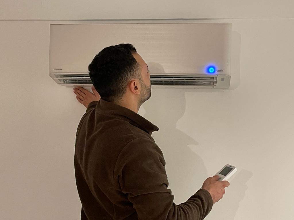 Technicien PAC Clim Paris 15 posant un climatiseur mural et une unité extérieure